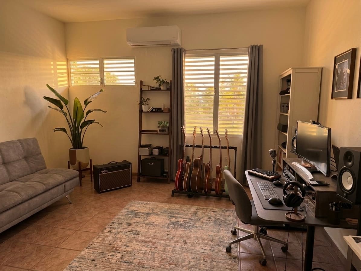 A home recording studio at golden hour, guitars racked beside a mixing desk